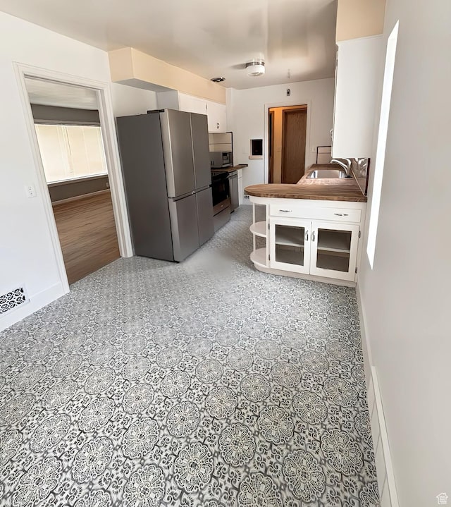 175 E 700 N, Logan, UT 84321 - kitchen featuring range with electric stovetop, white cabinets, freestanding refrigerator, and a sink