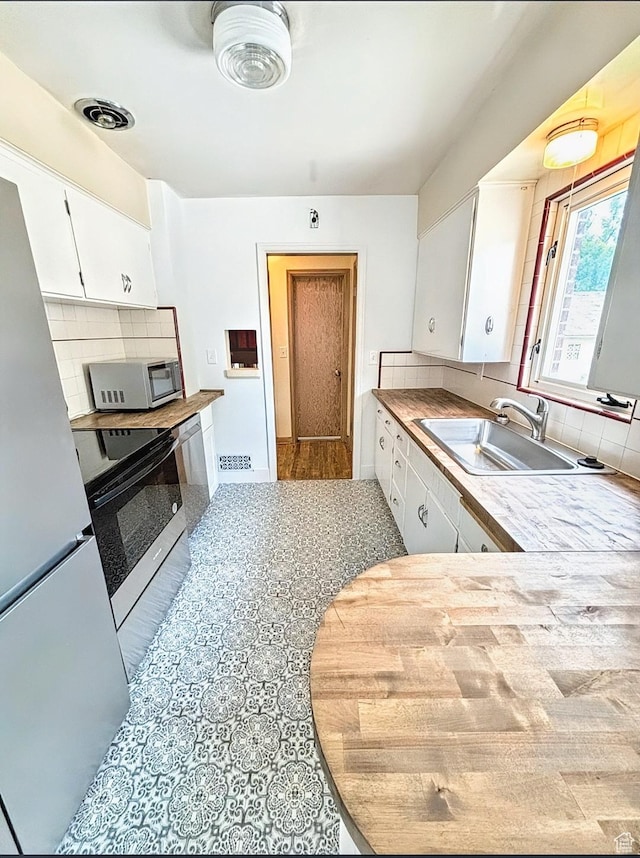 175 E 700 N, Logan, UT 84321 - kitchen with white appliances, visible vents, a sink, white cabinetry, and backsplash