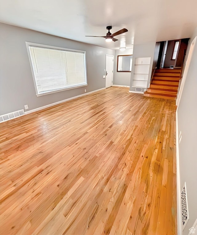 175 E 700 N, Logan, UT 84321 - unfurnished living room featuring stairway, baseboards, visible vents, ceiling fan, and light wood-type flooring