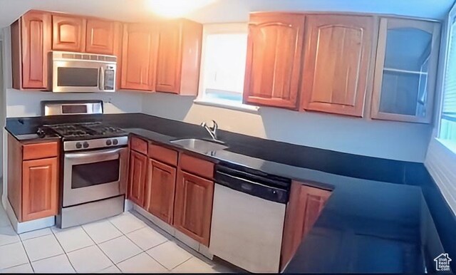 175 E 700 N, Logan, UT 84321 - kitchen featuring dark countertops, light tile patterned floors, appliances with stainless steel finishes, and a sink