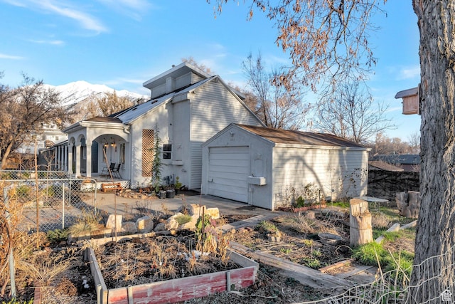 661 E 2735 S, Ogden, UT 84403 - rear view of house with a storage unit, fence, a mountain view, a vegetable garden, and an outdoor structure
