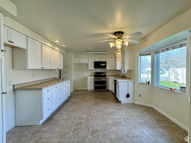 315 S 300 W, Santaquin, UT 84655 - kitchen featuring baseboards, a sink, black microwave, double oven range, and white cabinetry