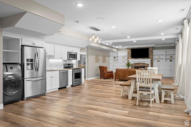 1336 S 2650 E, Springville, UT 84663 - kitchen with washer / dryer, appliances with stainless steel finishes, light wood-type flooring, and a large fireplace