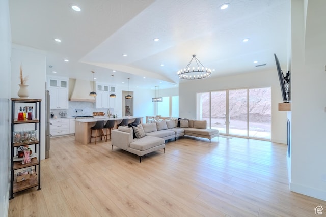 1683 S Painted Vista Cir, Washington, UT 84780 - living room with a notable chandelier, plenty of natural light, light wood finished floors, and vaulted ceiling