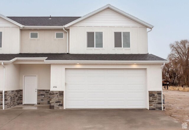 200 S 460 W Unit 4, Delta, UT 84624 - view of front of property featuring stone siding, an attached garage, a shingled roof, and driveway
