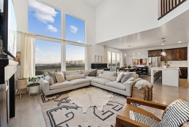 2101 W 980 S, Orem, UT 84059 - living room featuring light wood-style flooring, a fireplace, and a high ceiling