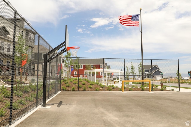 view of basketball court with a residential view, community basketball court, and fence