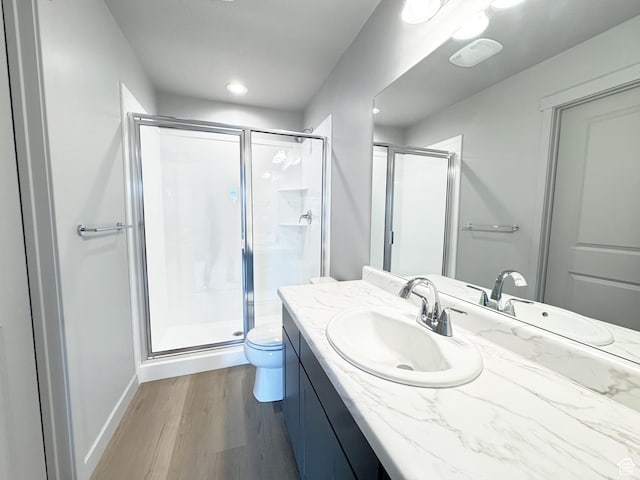 full bath featuring vanity, toilet, wood finished floors, and a shower stall
