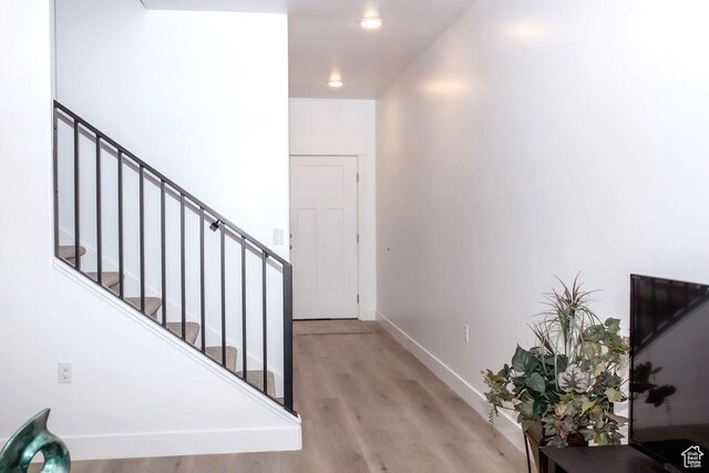 staircase featuring wood finished floors and baseboards