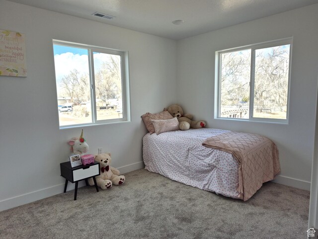 carpeted bedroom featuring visible vents and baseboards