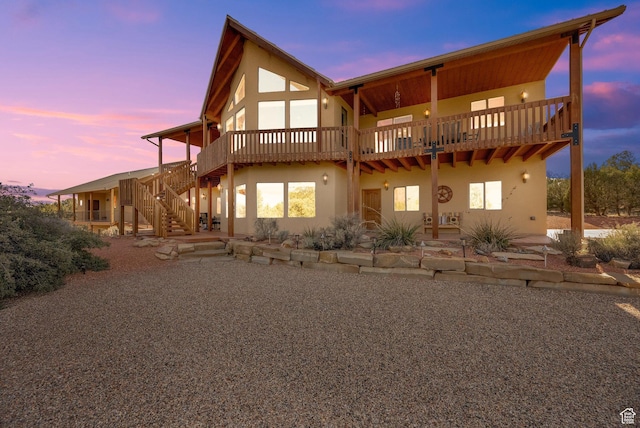 1617 N Mount Zion Dr, Apple Valley, UT 84737 - back of house at dusk featuring stairs, stucco siding, and a patio area
