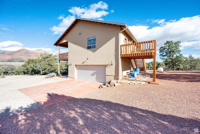 1617 N Mount Zion Dr, Apple Valley, UT 84737 - view of side of home with concrete driveway, stucco siding, stairway, an attached garage, and a mountain view