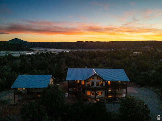 1617 N Mount Zion Dr, Apple Valley, UT 84737 - back of house at dusk featuring metal roof, a mountain view, and a view of trees