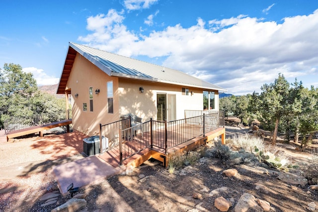 1617 N Mount Zion Dr, Apple Valley, UT 84737 - rear view of property featuring central AC unit, metal roof, stucco siding, and a wooden deck