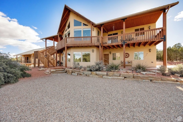 rear view of property featuring stairs, stucco siding, and a patio area