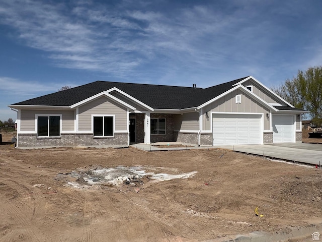 2861 N 3475 W Unit 15, Plain City, UT 84404 - view of front facade with concrete driveway, brick siding, board and batten siding, and an attached garage