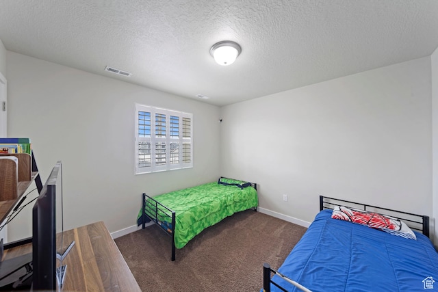carpeted bedroom featuring visible vents, a textured ceiling, and baseboards
