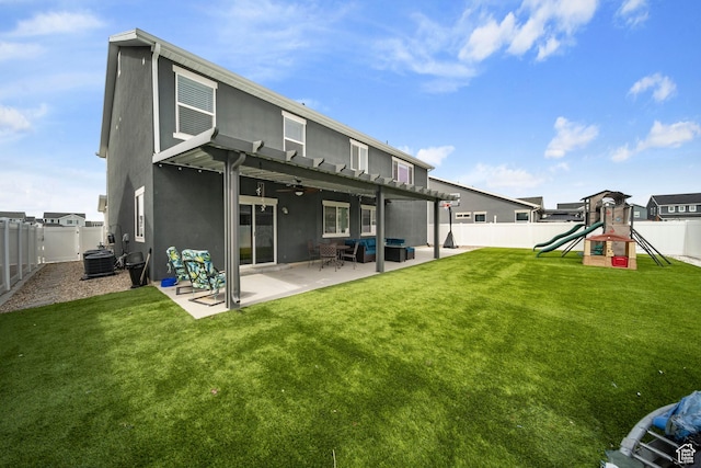 rear view of property featuring a yard, a fenced backyard, stucco siding, a playground, and a patio area