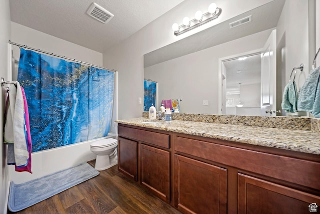 bathroom with visible vents, toilet, vanity, and wood finished floors
