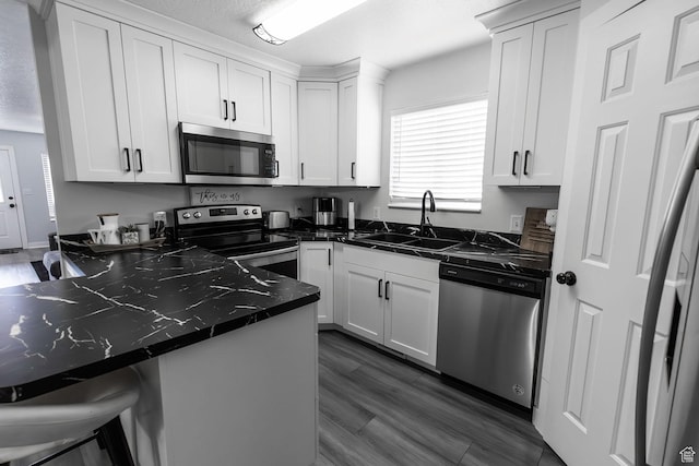 832 S 1430 E, Spanish Fork, UT 84660 - kitchen with appliances with stainless steel finishes, dark countertops, a sink, white cabinets, and a breakfast bar area