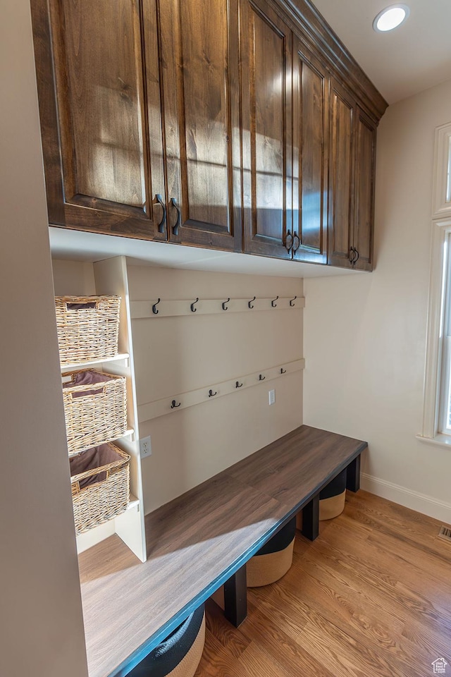 mudroom featuring light wood finished floors and baseboards