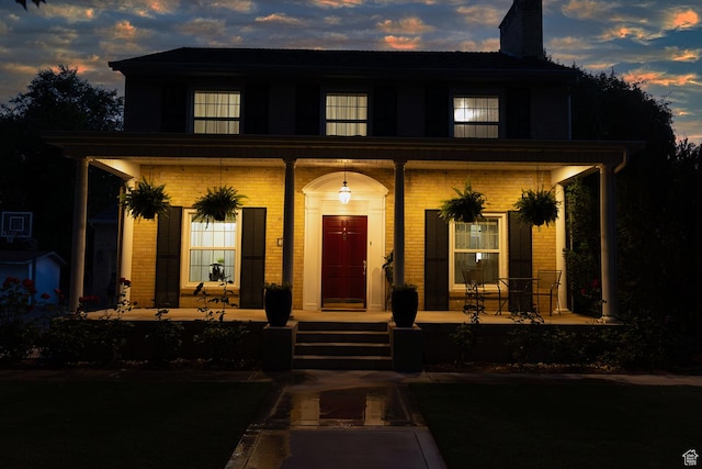 view of front of house with covered porch and a chimney