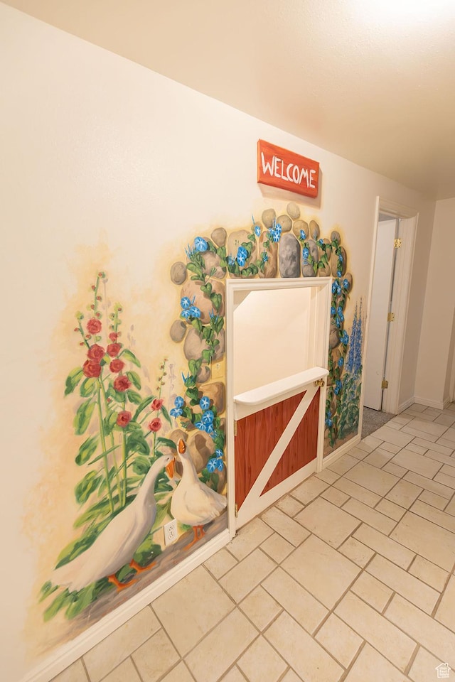 interior space with light tile patterned floors and baseboards