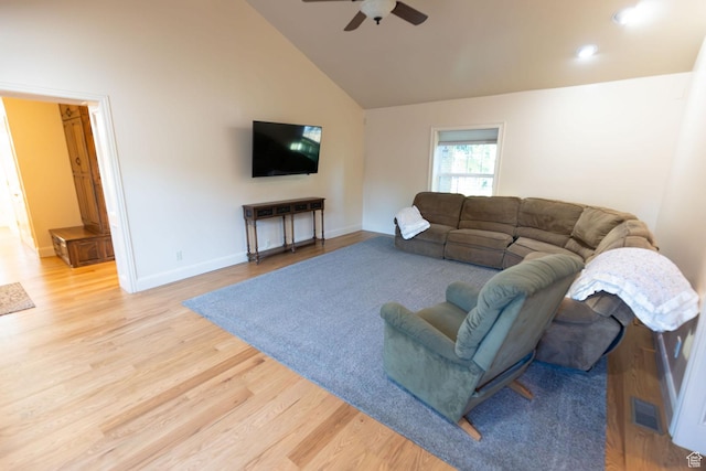 living room with visible vents, baseboards, light wood-style flooring, high vaulted ceiling, and a ceiling fan