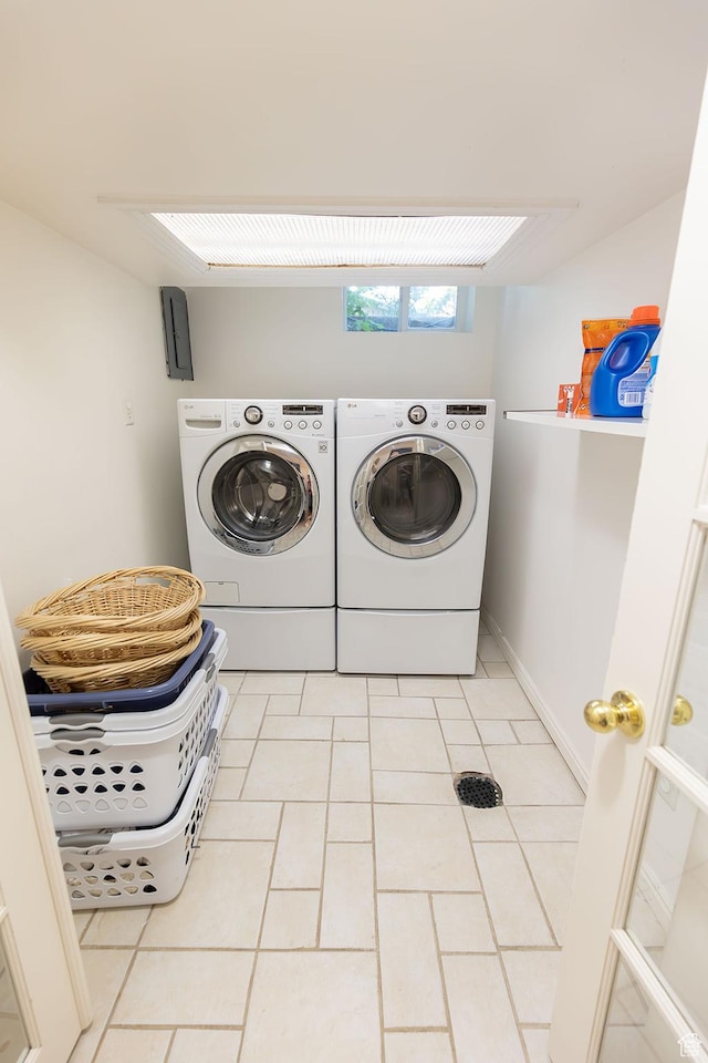 laundry area featuring light tile patterned floors, washing machine and dryer, and laundry area