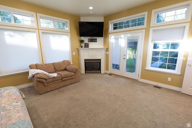 living room with visible vents, baseboards, carpet, recessed lighting, and a glass covered fireplace
