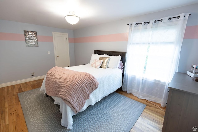 bedroom featuring light wood-style floors and baseboards