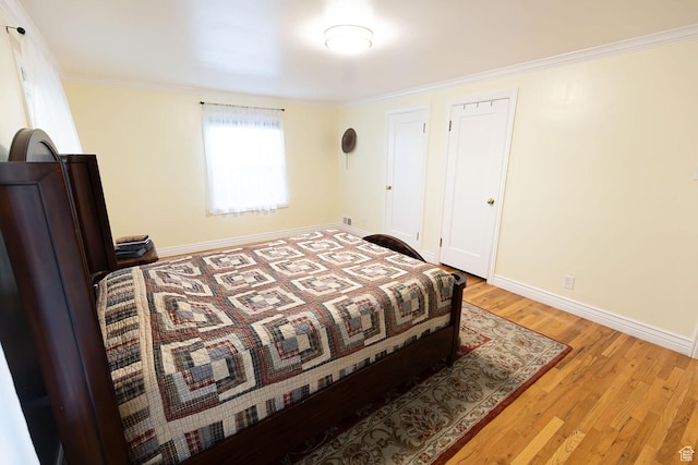 bedroom with baseboards, wood finished floors, and ornamental molding