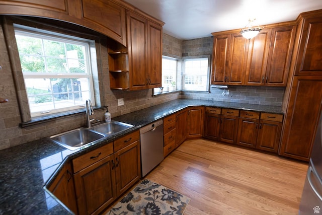 kitchen with backsplash, dishwasher, light wood-style flooring, brown cabinetry, and a sink