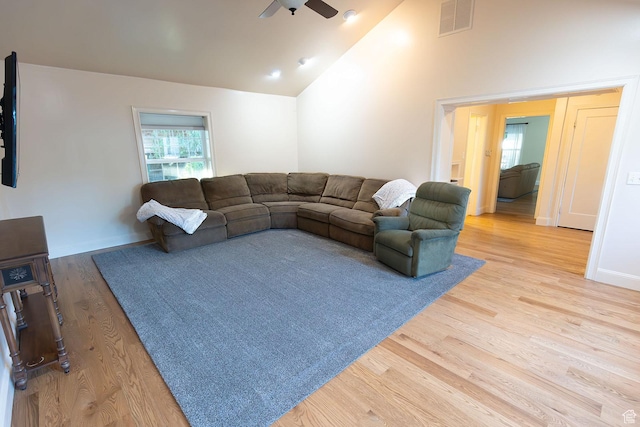 living room featuring visible vents, baseboards, ceiling fan, wood finished floors, and high vaulted ceiling