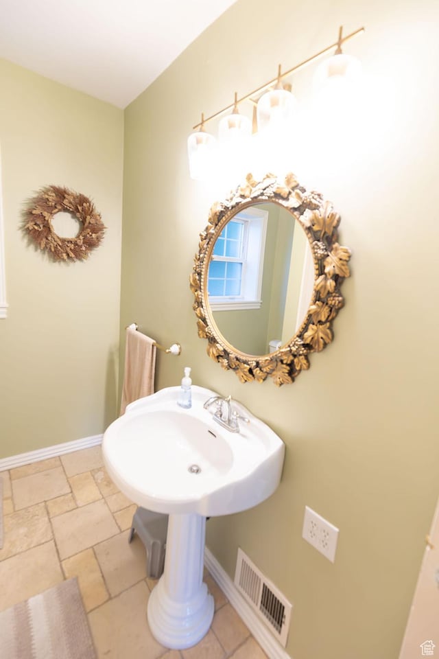 bathroom with baseboards, visible vents, and stone tile flooring