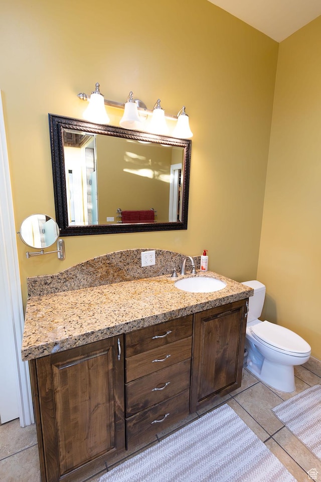 half bathroom featuring vanity, tile patterned floors, and toilet