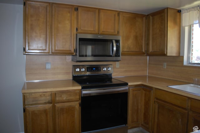 71 Gary Way N, Salt Lake, UT 84054 - kitchen with appliances with stainless steel finishes, light countertops, and brown cabinetry