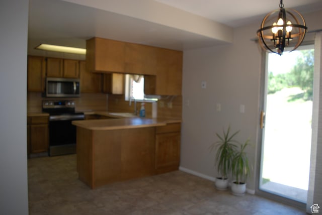 71 Gary Way N, Salt Lake, UT 84054 - kitchen featuring stainless steel appliances, a peninsula, a chandelier, light countertops, and pendant lighting