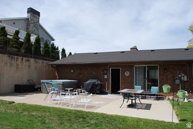 71 Gary Way N, Salt Lake, UT 84054 - back of property with brick siding, fence, a shingled roof, a hot tub, and a patio area