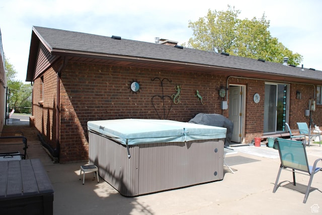 71 Gary Way N, Salt Lake, UT 84054 - rear view of house featuring brick siding, a patio area, and a hot tub
