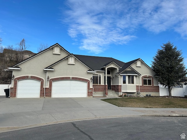view of front of property with brick siding, a garage, and stucco siding