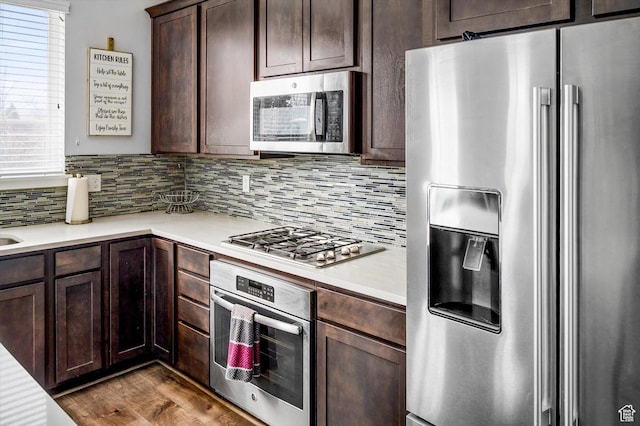12172 S Window Arch Ln, Herriman, UT 84096 - kitchen with decorative backsplash, light countertops, dark brown cabinets, and appliances with stainless steel finishes