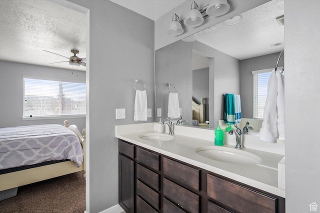12172 S Window Arch Ln, Herriman, UT 84096 - bathroom featuring a ceiling fan, a sink, connected bathroom, and a textured ceiling