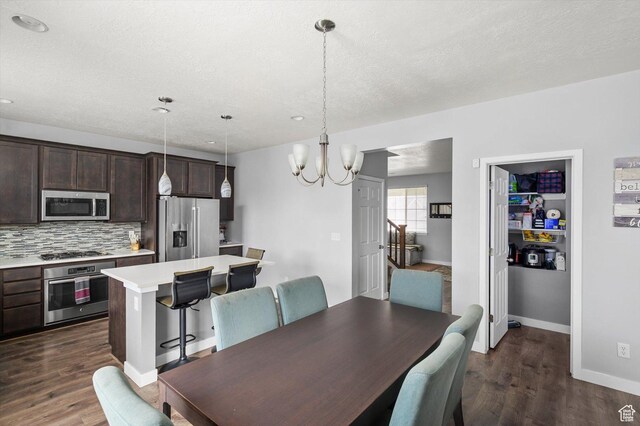 12172 S Window Arch Ln, Herriman, UT 84096 - dining space featuring dark wood-type flooring, baseboards, a chandelier, and a textured ceiling