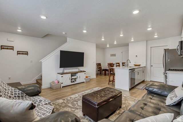 1436 S Divide Dr, Santaquin, UT 84655 - living room featuring baseboards, recessed lighting, light wood-style flooring, and stairway