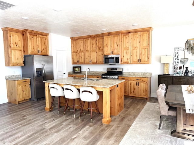 352 W Ropelato Dr, Nibley, UT 84321 - kitchen with stainless steel appliances, a sink, light wood-type flooring, recessed lighting, and a breakfast bar area