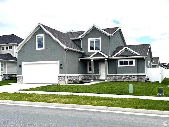 352 W Ropelato Dr, Nibley, UT 84321 - view of front of house featuring stucco siding, a garage, stone siding, concrete driveway, and covered porch
