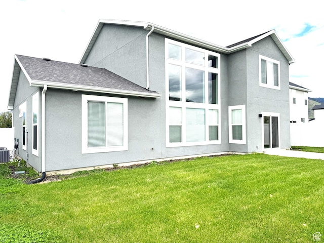 352 W Ropelato Dr, Nibley, UT 84321 - rear view of property featuring stucco siding, a lawn, and central AC unit