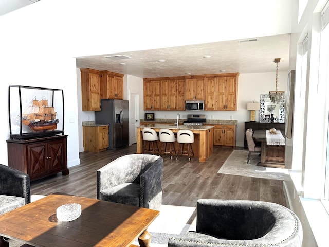 352 W Ropelato Dr, Nibley, UT 84321 - kitchen featuring stainless steel appliances, a sink, a kitchen bar, wood finished floors, and recessed lighting