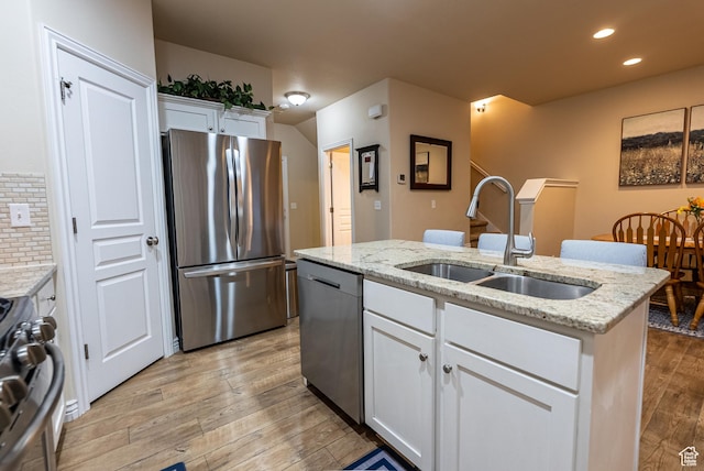 160 S 2775 W, West Point, UT 84015 - kitchen featuring a center island with sink, a sink, stainless steel appliances, white cabinets, and light wood finished floors